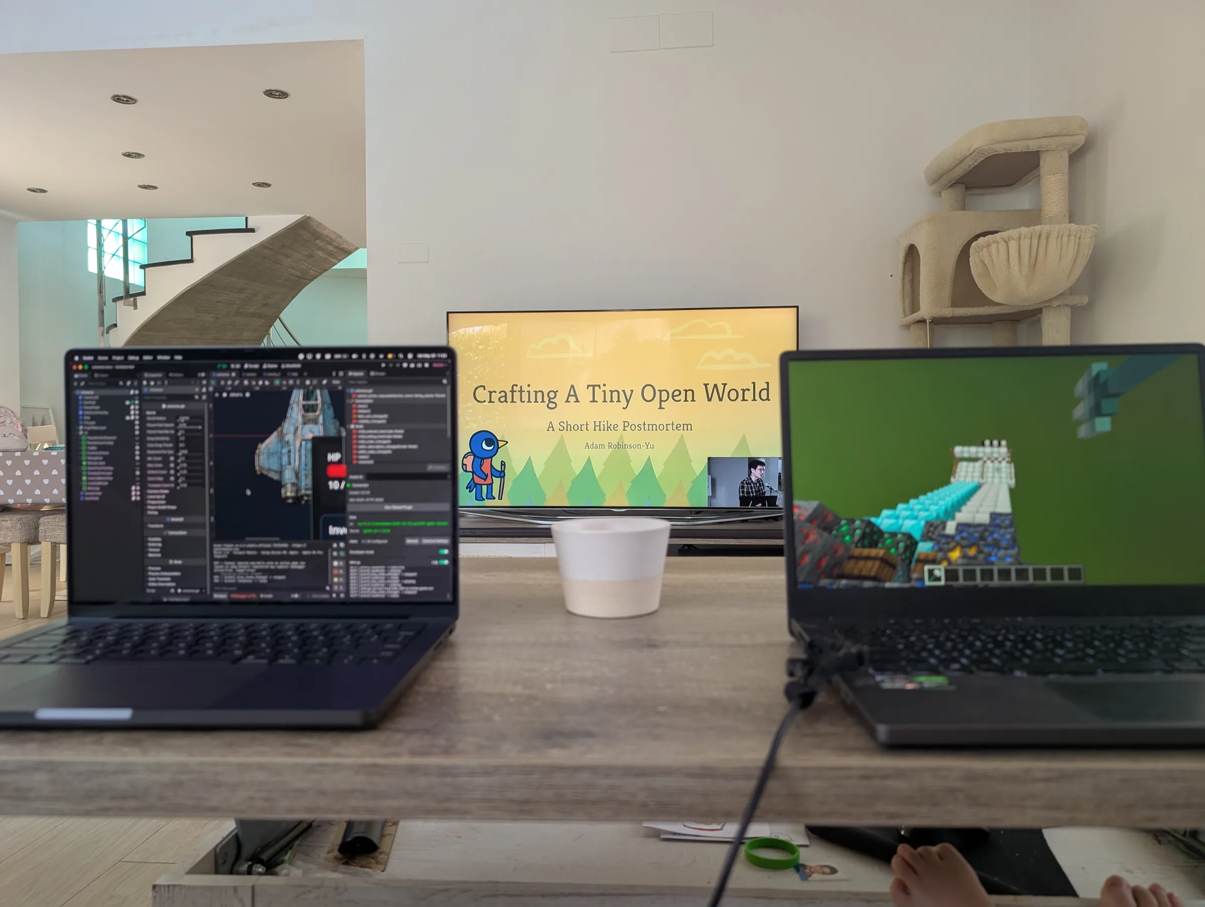 Two laptops on a table: one running Unobserved in Godot and the other showing Minecraft, with a GDC talk about A Short Hike playing on the television